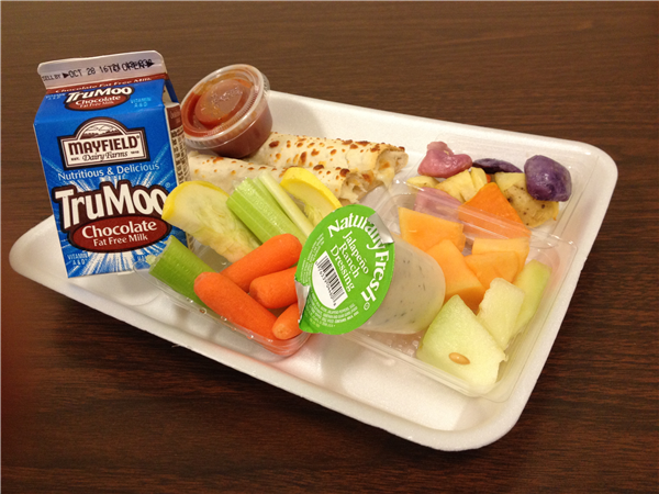 School lunch tray with fresh fruits, vegetables, chocolate milk, and entree